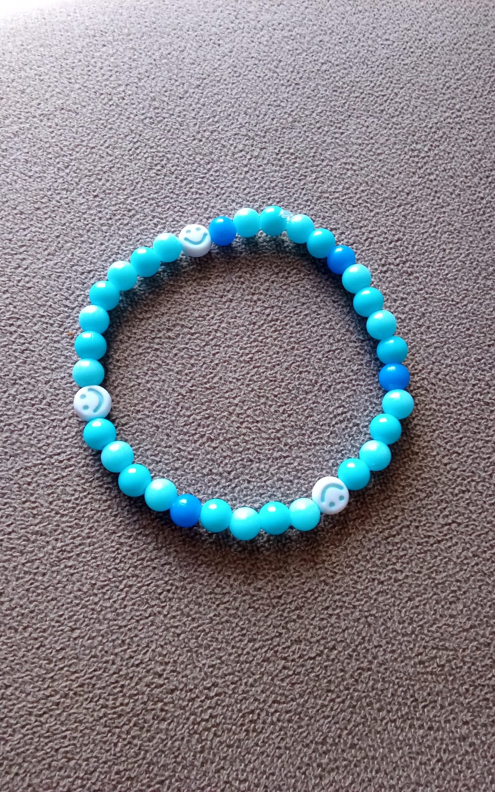 Pulseira artesanal azul com missangas coloridas